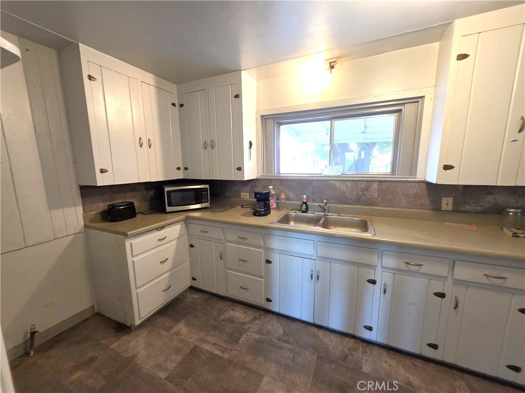 14055 Palm Street Cabazon, CA 92230 - Photo 15 of 22 a kitchen with white cabinets sink and window