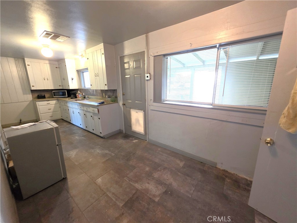 14055 Palm Street Cabazon, CA 92230 - Photo 18 of 22 a large white kitchen with a large window