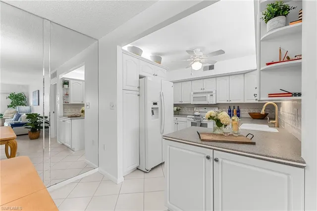 a kitchen with a refrigerator sink and white cabinets