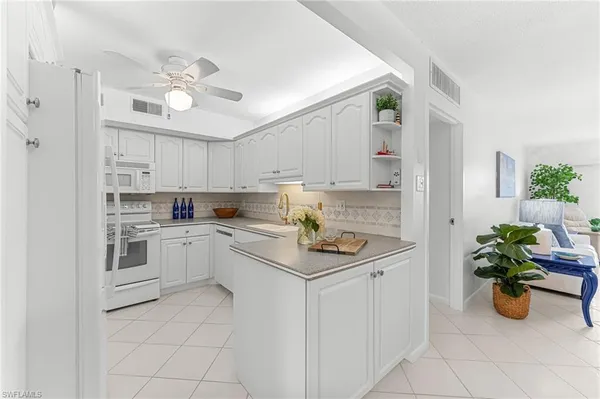 a kitchen with white cabinets and white appliances