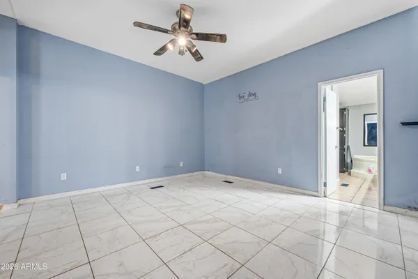 a view of an empty room and chandelier fan