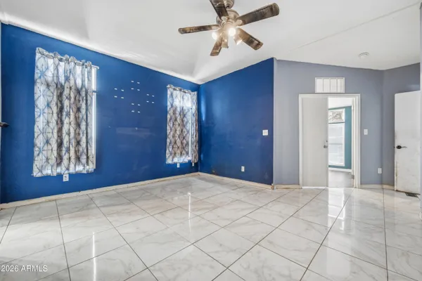 a view of a livingroom with a chandelier fan and windows