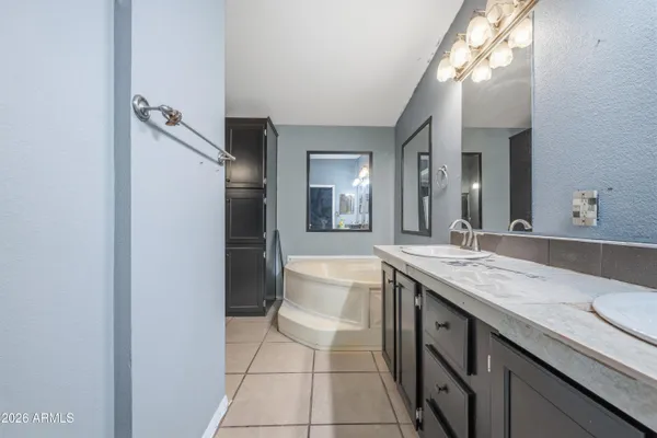 a spacious bathroom with a granite countertop sink and a mirror