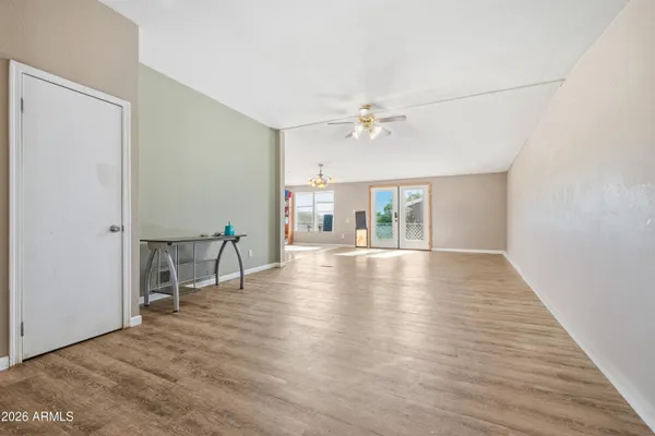 a view of an empty room with wooden floor and a window