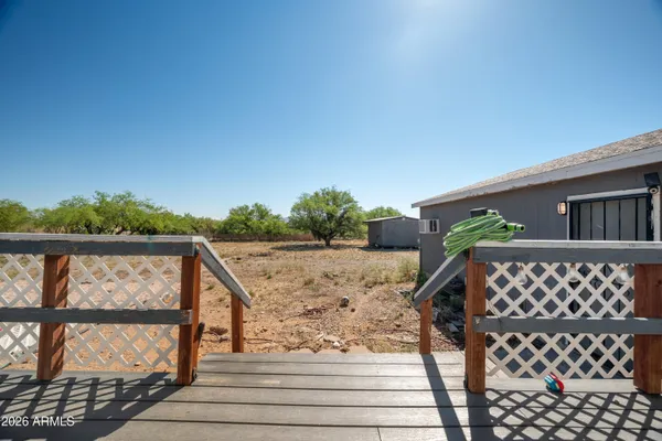 a view of balcony with wooden floor and fence