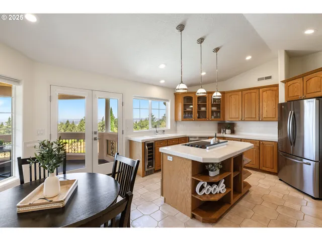 a kitchen with a table chairs refrigerator and wooden floor