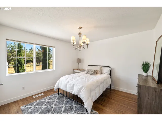 a bedroom with a bed chandelier and a window