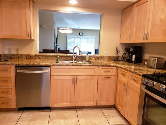 a kitchen with stainless steel appliances granite countertop a stove a sink and a microwave