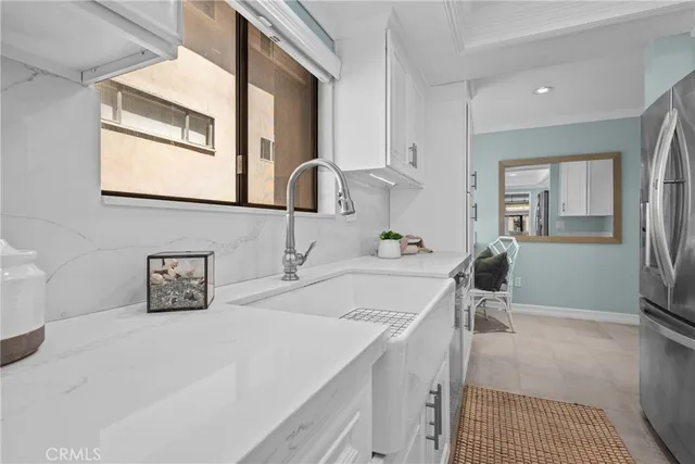 a kitchen with white cabinets and refrigerator