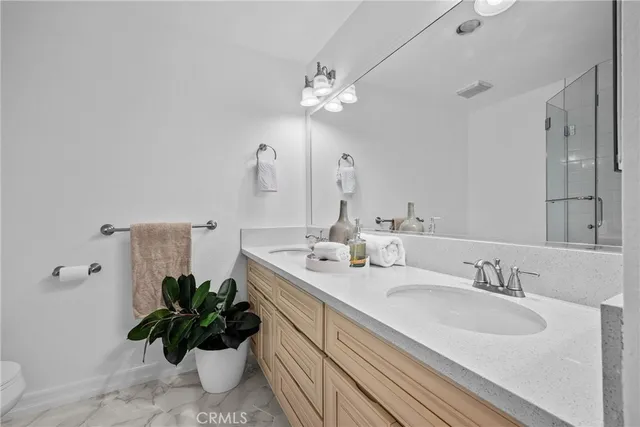 a bathroom with a granite countertop shower sink and mirror