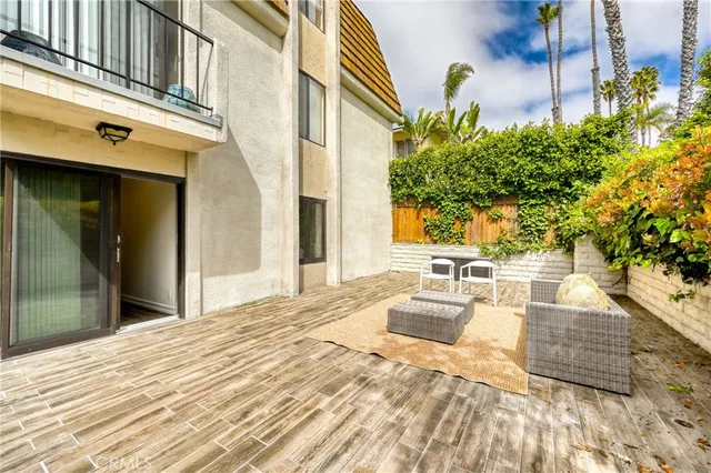a view of a patio with couches table and chairs and potted plants