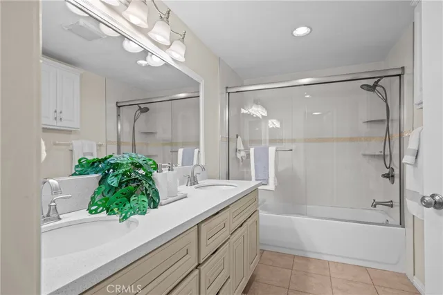 a bathroom with a granite countertop double vanity and a mirror