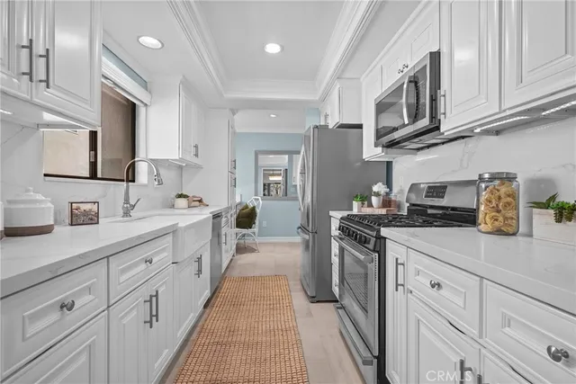 a kitchen with stainless steel appliances granite countertop a sink a stove top oven a counter space and cabinets