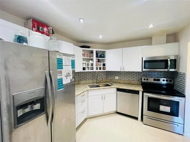 a kitchen with stainless steel appliances a stove microwave and refrigerator