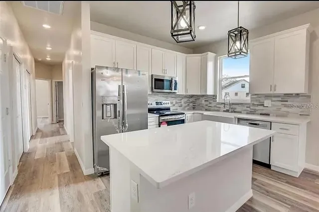 a kitchen with stainless steel appliances a refrigerator sink and microwave