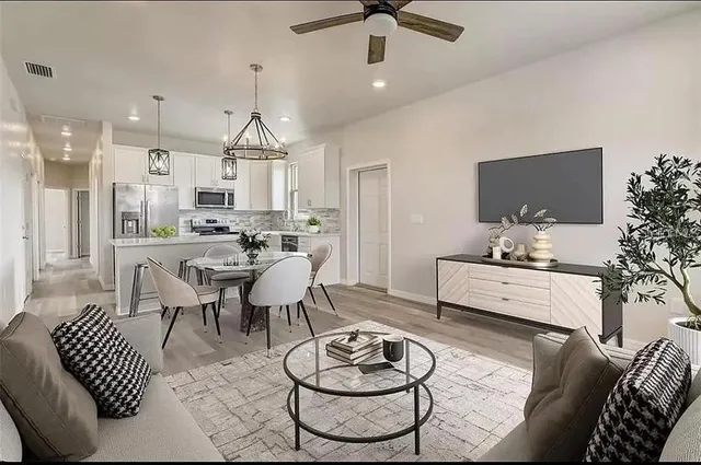 a living room with furniture and a dining table with kitchen view