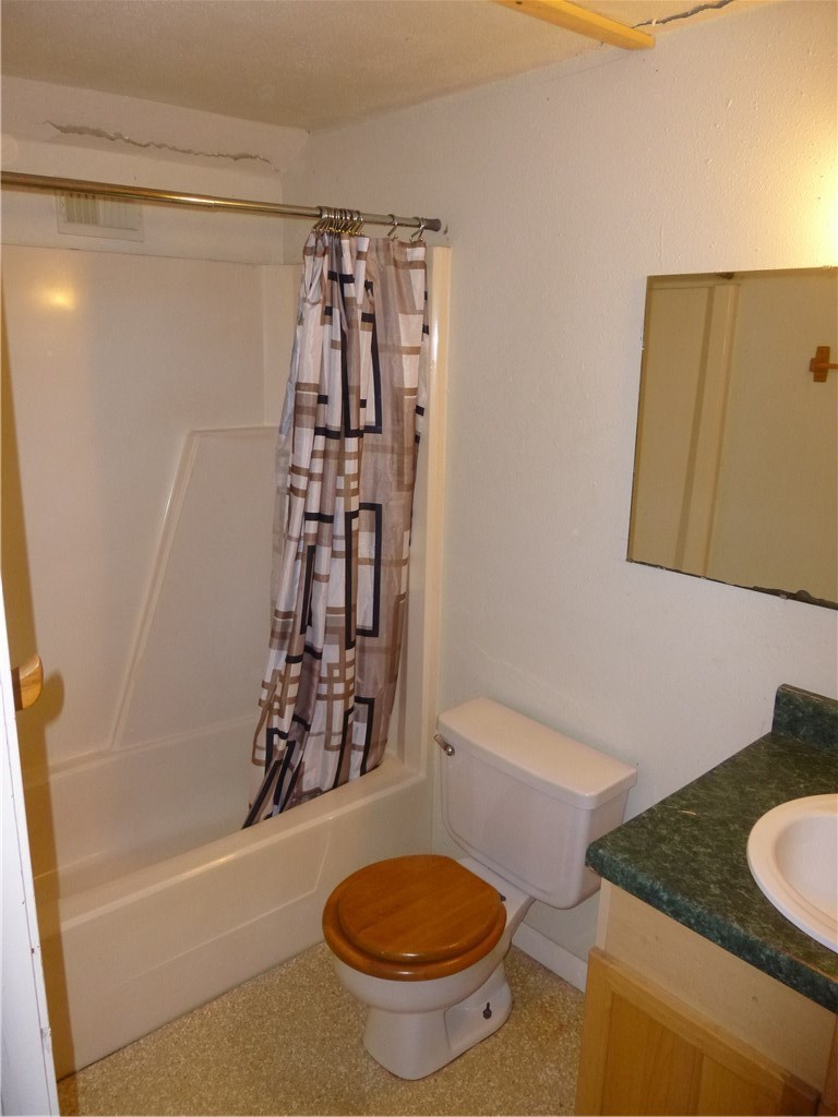 502 West 10th Street Taylor, TX 76574 - Photo 30 of 34 a bathroom with a granite countertop sink toilet and shower