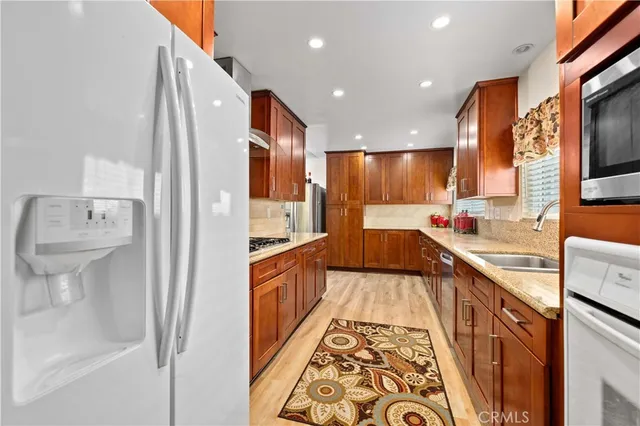 a large kitchen with stainless steel appliances a sink and cabinets