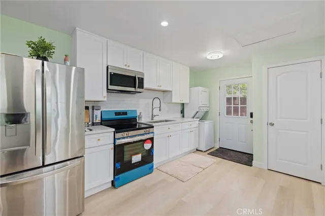a kitchen with white cabinets and stainless steel appliances