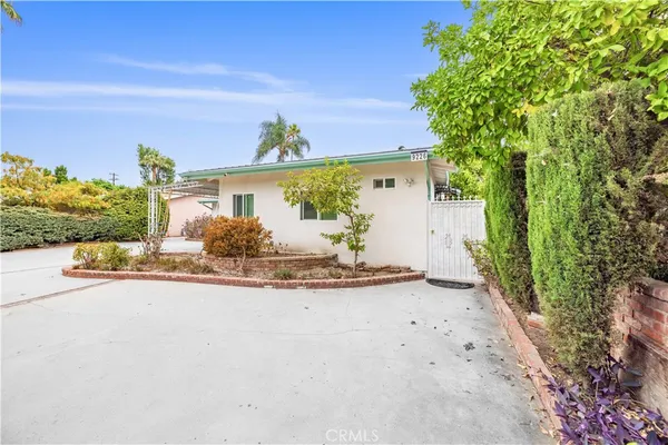 a view of a house with a yard and potted plants