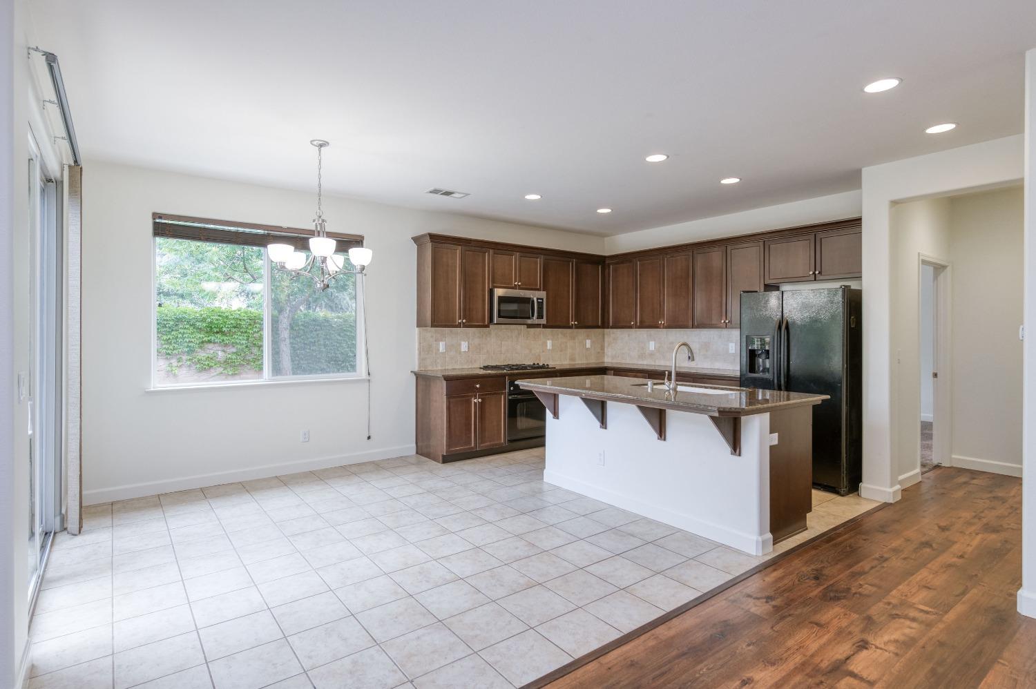 1697 North Connery Lane Clovis, CA 93619 - Photo 12 of 56 a kitchen with stainless steel appliances granite countertop a stove top oven a sink and a refrigerator