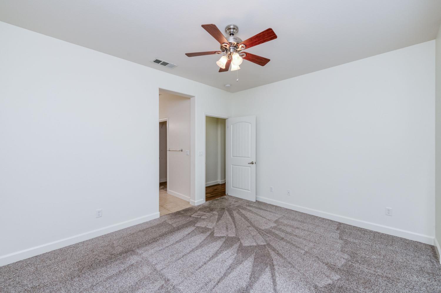 1697 North Connery Lane Clovis, CA 93619 - Photo 22 of 56 an empty room with closet and a ceiling fan