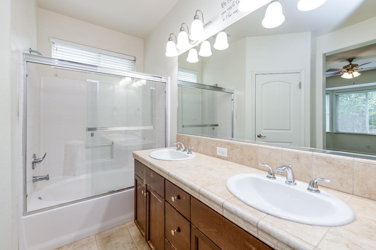 1697 North Connery Lane Clovis, CA 93619 - Photo 23 of 56 a bathroom with a sink double vanity granite tub and a mirror