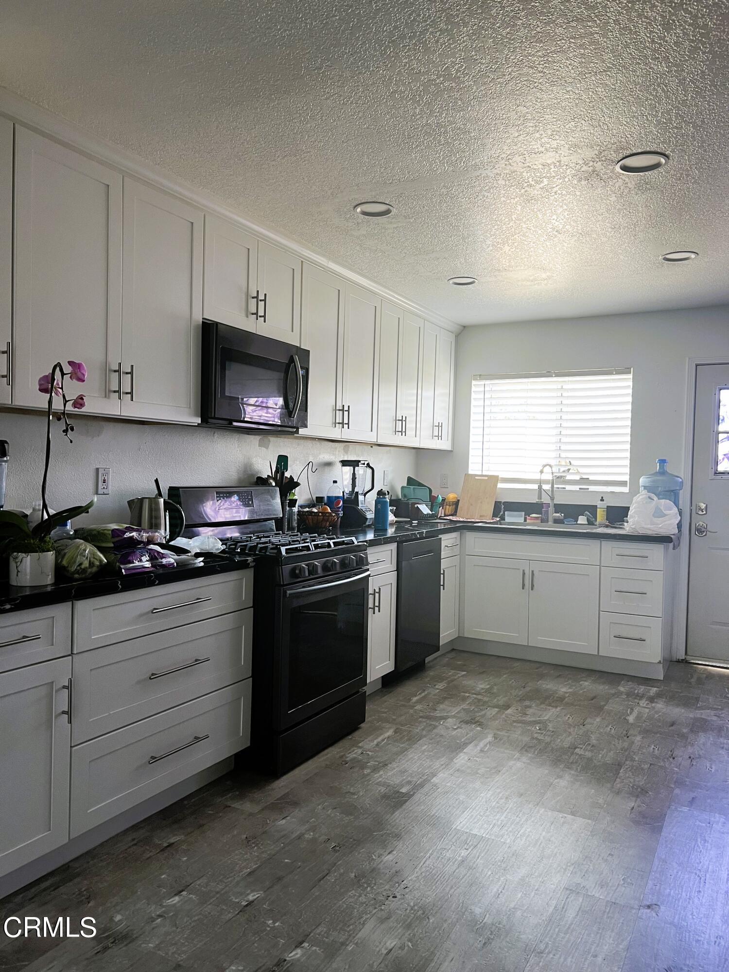 511 East Bard Road, Unit 16 Oxnard, CA 93033 - Photo 8 of 13 a kitchen with stainless steel appliances granite countertop a stove top oven a sink a refrigerator and white cabinets