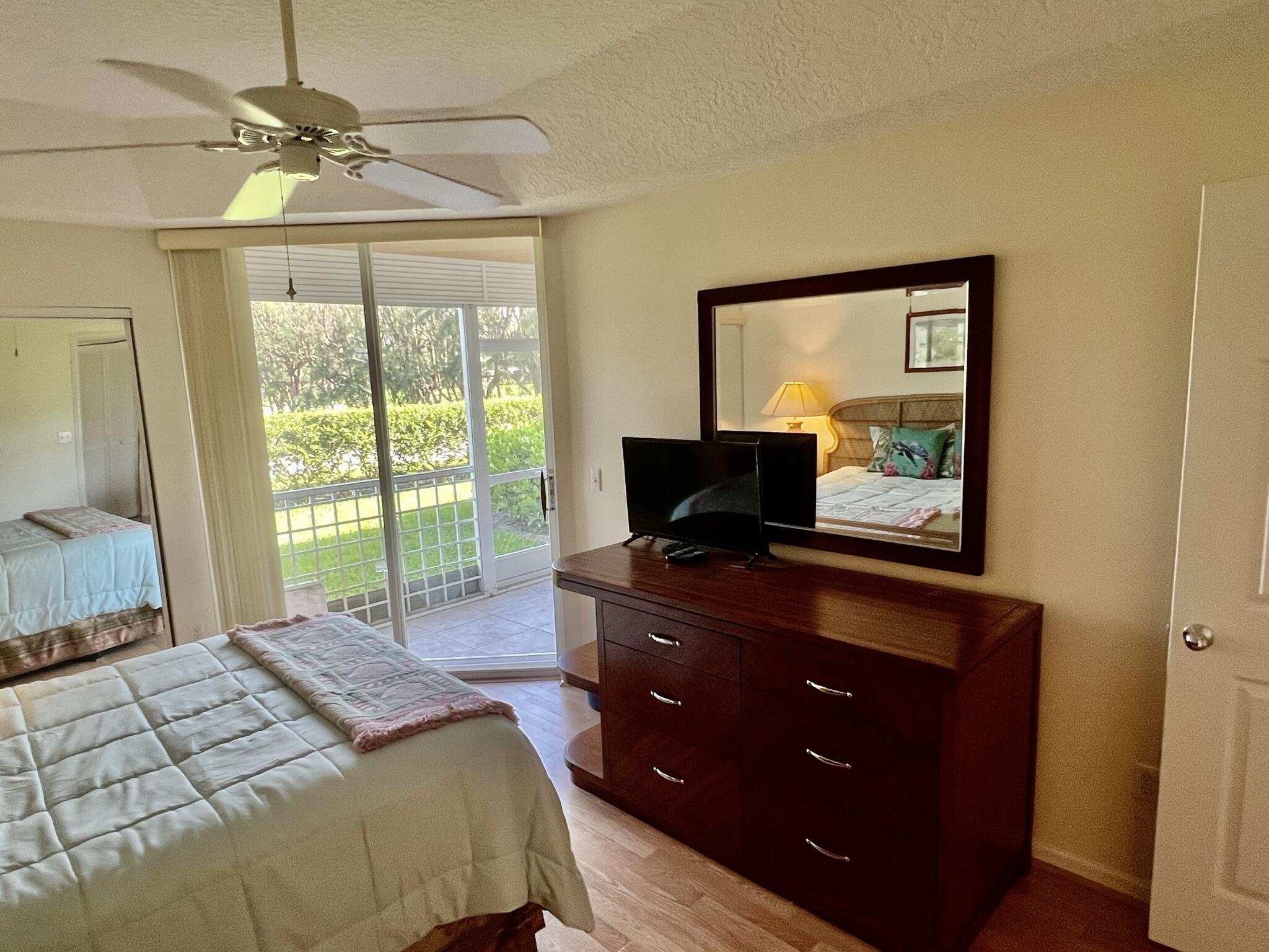 101 Muirfield Court, Unit F Jupiter, FL 33458 - Photo 13 of 20 a bedroom with a bed and a television