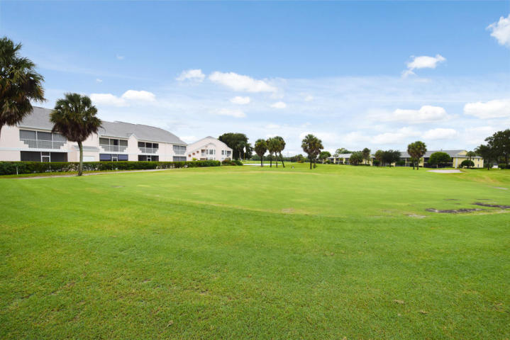 101 Muirfield Court, Unit F Jupiter, FL 33458 - Photo 20 of 20 a view of a big yard with a house in the background