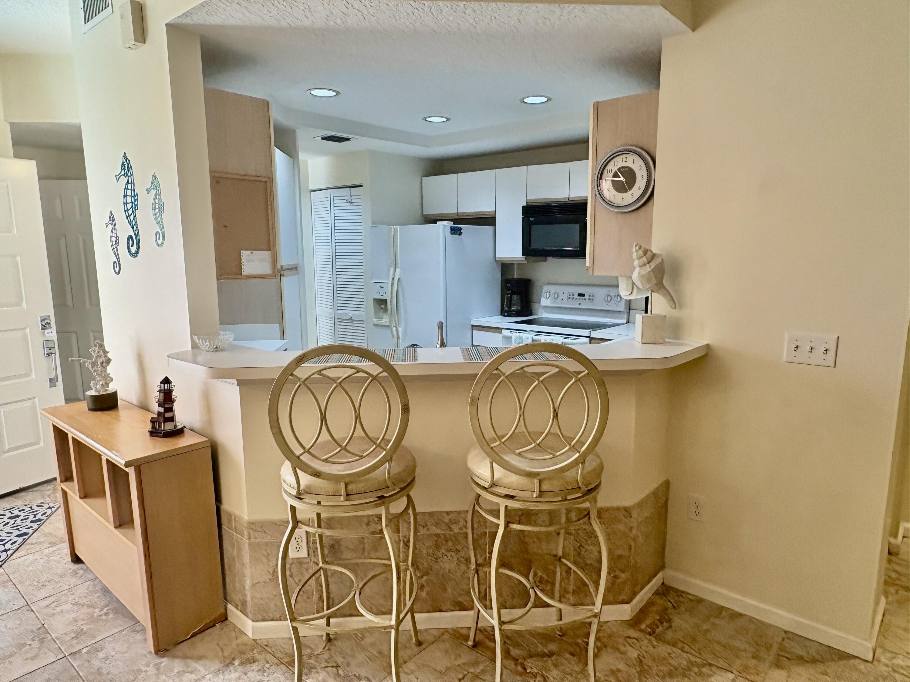 101 Muirfield Court, Unit F Jupiter, FL 33458 - Photo 9 of 20 a view of a kitchen with stainless steel appliances granite countertop a stove and a sink
