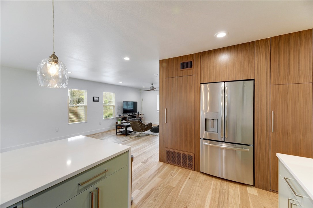 a modern kitchen with stainless steel appliances a refrigerator and wooden floor