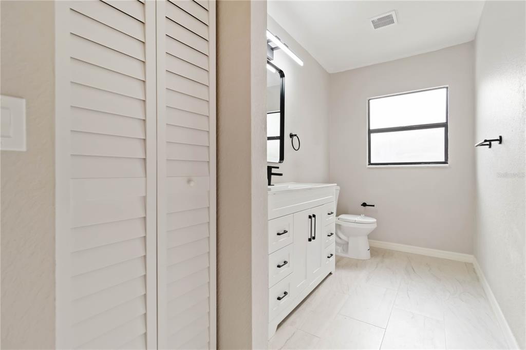 1368 21st Street Sarasota, FL 34234 - Photo 20 of 34 a bathroom with a double vanity sink a toilet and a window
