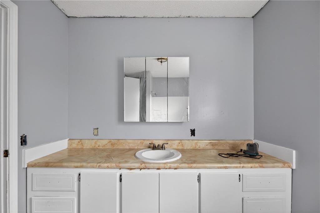 712 West 5th Highway Roopville, GA 30170 - Photo 19 of 29 a bathroom with a granite countertop sink and a mirror