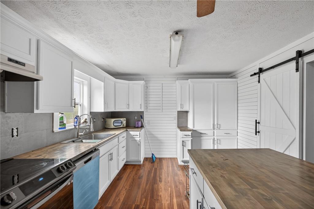 712 West 5th Highway Roopville, GA 30170 - Photo 9 of 29 a kitchen with granite countertop a sink a counter space appliances and cabinets
