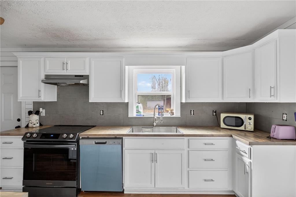 712 West 5th Highway Roopville, GA 30170 - Photo 10 of 29 a kitchen with white cabinets and appliances