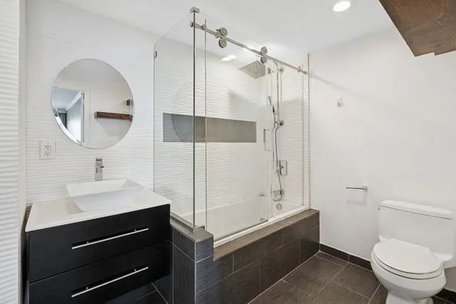 a bathroom with a sink a toilet and shower