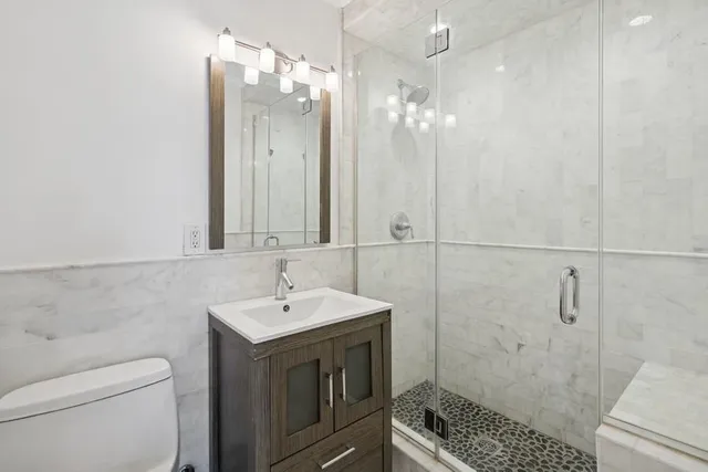 a bathroom with a sink a toilet and shower