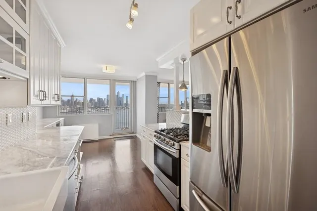 a kitchen with stainless steel appliances granite countertop a refrigerator and a stove top oven