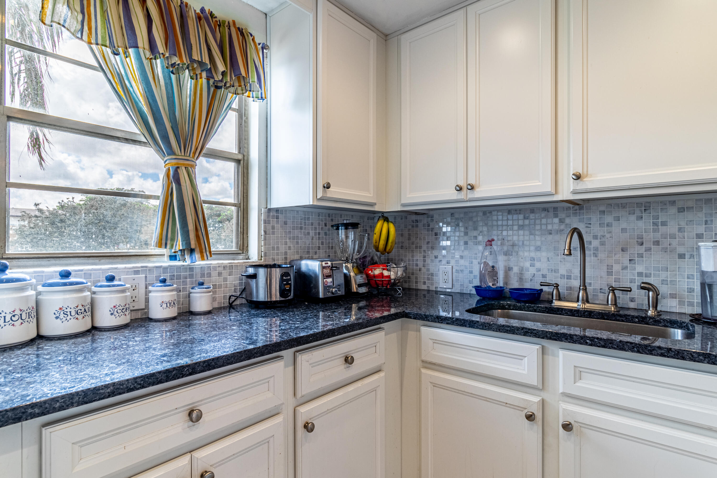 351 Mansfield I Boca Raton, FL 33434 - Photo 14 of 18 a kitchen with stainless steel appliances white cabinets and a window