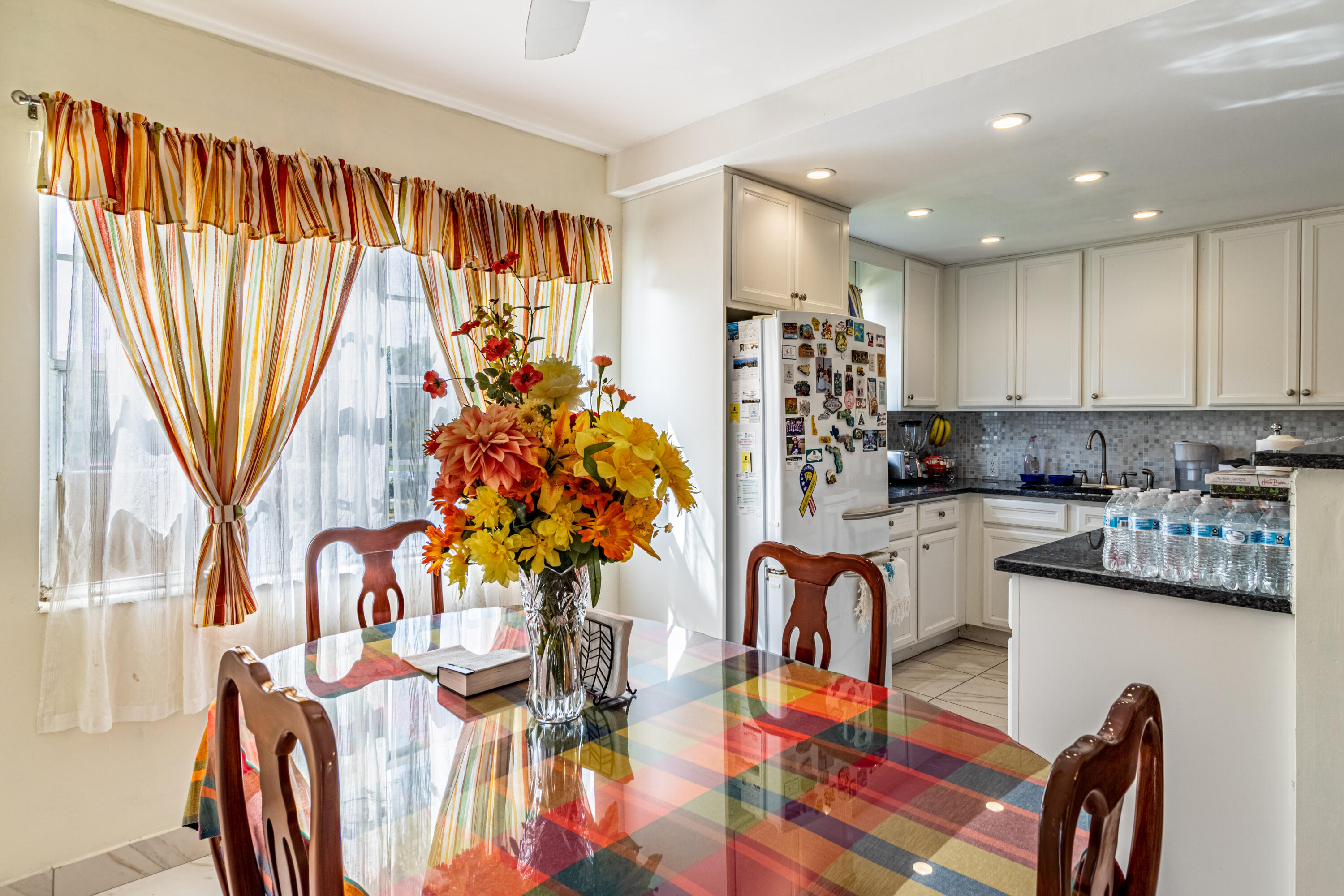 351 Mansfield I Boca Raton, FL 33434 - Photo 17 of 18 a kitchen with stainless steel appliances granite countertop a refrigerator a stove a sink dishwasher and a dining table with wooden floor