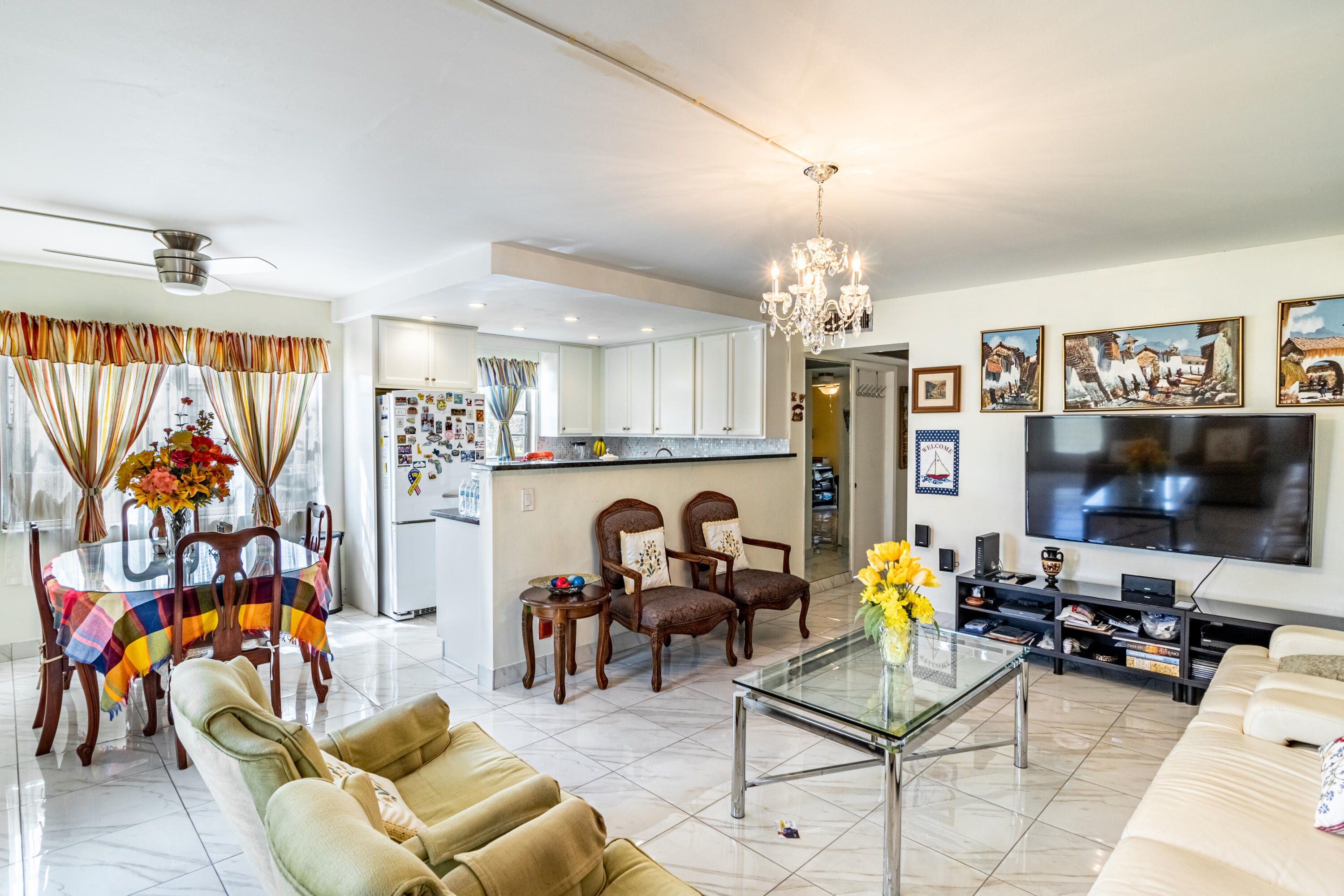 351 Mansfield I Boca Raton, FL 33434 - Photo 3 of 18 a living room with furniture a flat screen tv and a chandelier