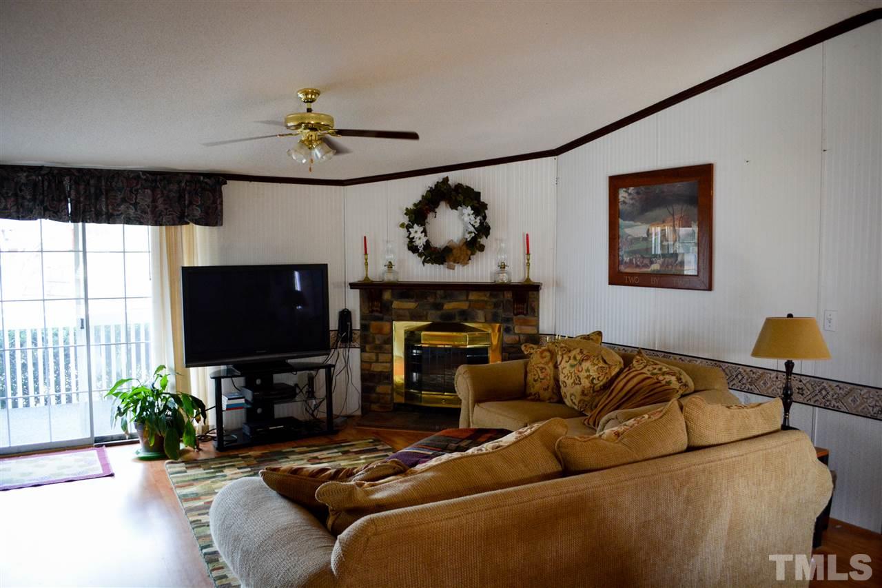 7236 Pecan Tree Street Willow Spring, NC 27592 - Photo 19 of 25 a living room with furniture a fireplace and a flat screen tv