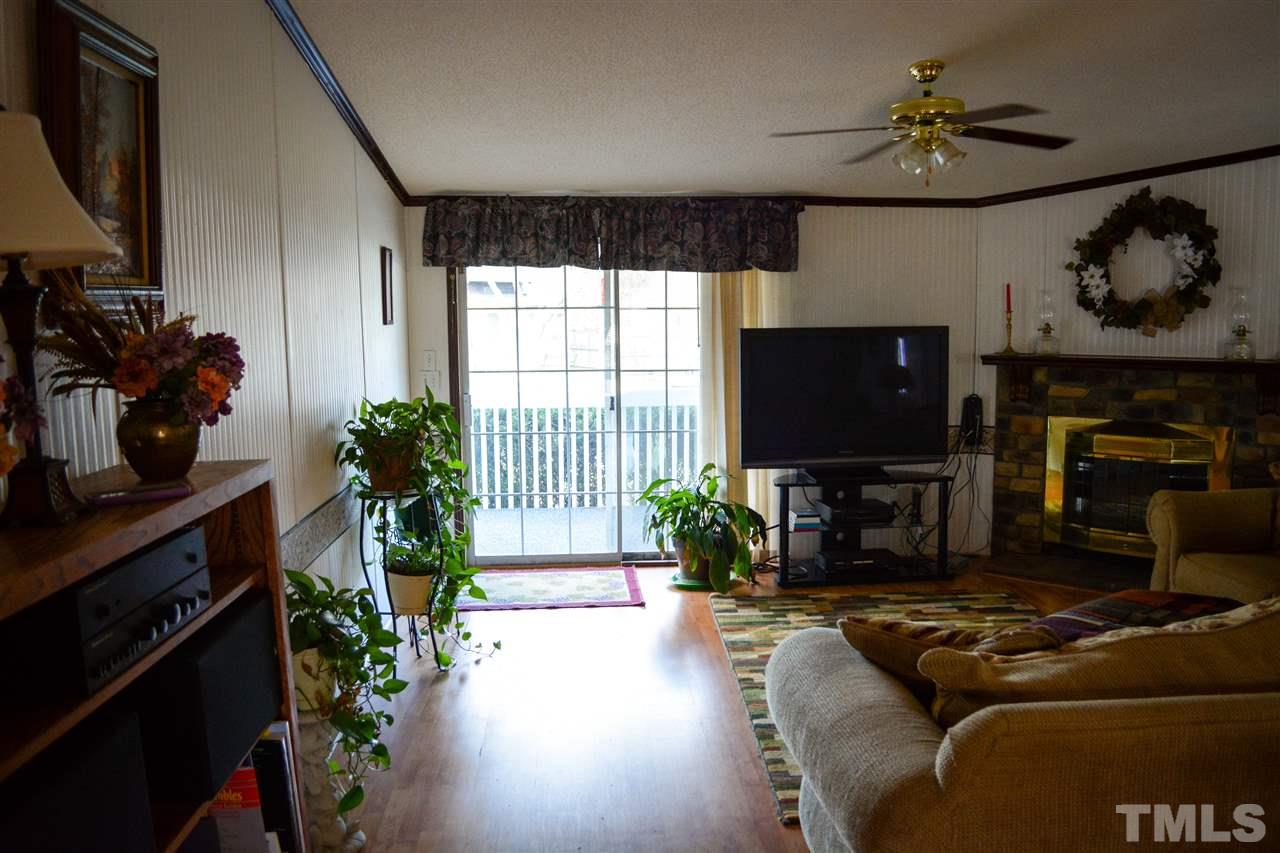 7236 Pecan Tree Street Willow Spring, NC 27592 - Photo 20 of 25 a living room with furniture a flat screen tv and a fireplace