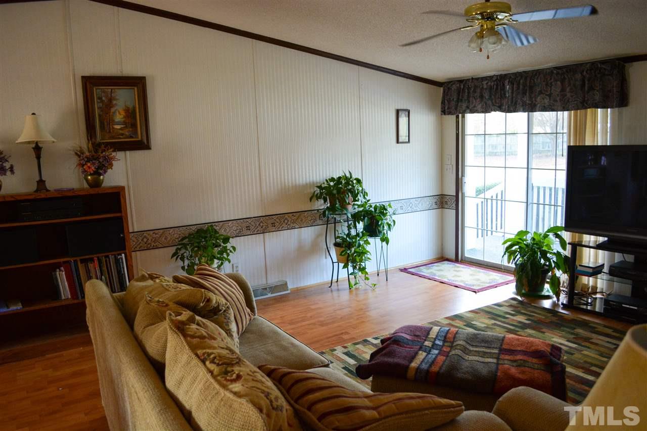 7236 Pecan Tree Street Willow Spring, NC 27592 - Photo 21 of 25 a living room with furniture dining table and a potted plant