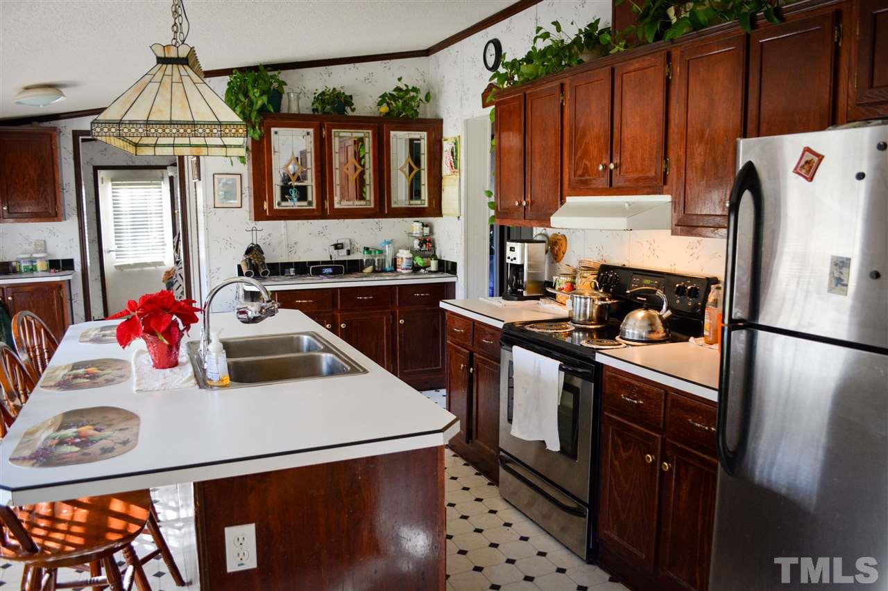 7236 Pecan Tree Street Willow Spring, NC 27592 - Photo 5 of 25 a kitchen with a sink a stove and refrigerator