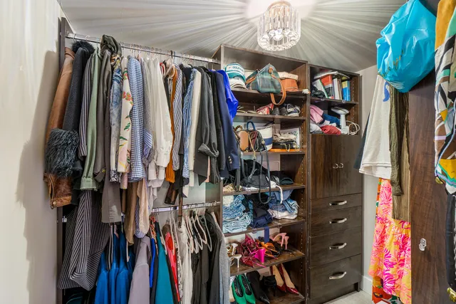 a view of walk in closet with clothes