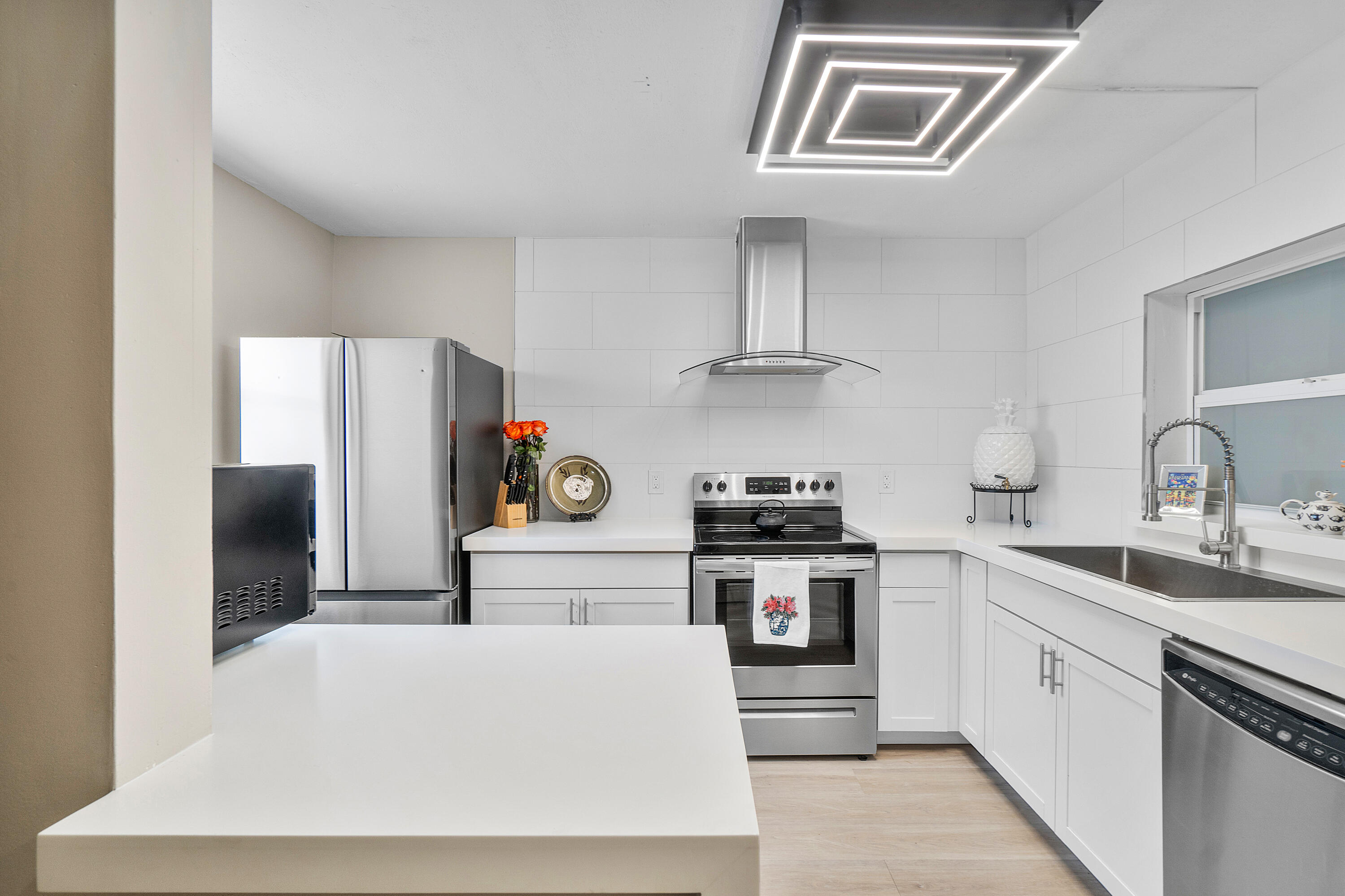 2805 Southwest 22nd Avenue, Unit 1040 Delray Beach, FL 33445 - Photo 2 of 18 a kitchen with stainless steel appliances a sink and cabinets