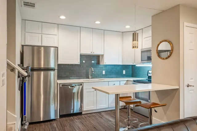 a kitchen with stainless steel appliances granite countertop a refrigerator and a stove top oven