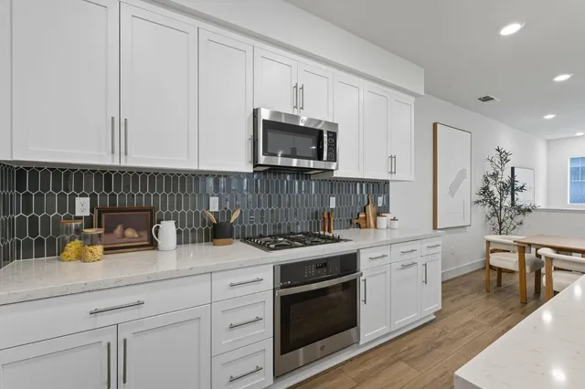 a kitchen with stainless steel appliances granite countertop a stove a sink and a microwave
